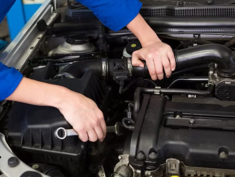 Technician working on an engine with a socket wrench