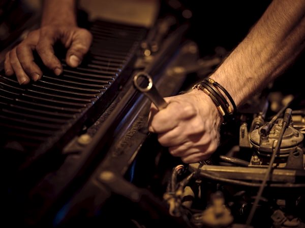 Mechanic servicing an engine with a wrench